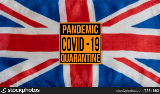 Pandemic sign warning of quarantine due to Covid-19 or corona virus in the UK using a british flag in the background. Pandemic sign warning of quarantine due to Covid-19 or corona virus in the UK