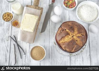 Panettone with ingredients on the white wooden table