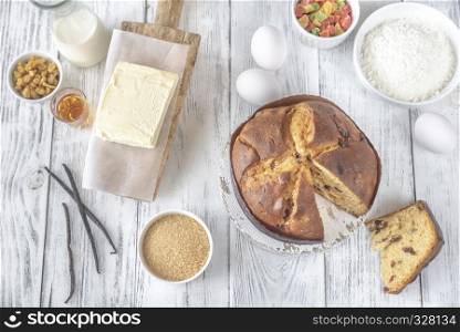 Panettone with ingredients on the white wooden table