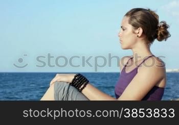 Panning on attractive young caucasian woman looking at the sea. Copy space