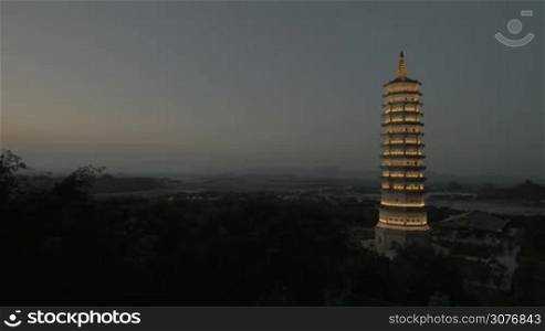 Panning shot of Bai Dinh Pagoda complex at night with illuminated high tower temple. Sightseeing of Vietnam