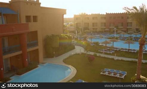 Panning shot of summer resort with hotels and swimming pool on its territory