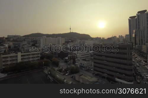 Panning wide angle shot of evening Seoul in South Korea. City buildings and car traffic on the motorways at sunset