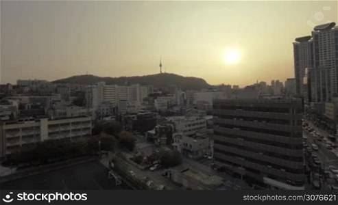 Panning wide angle shot of evening Seoul in South Korea. City buildings and car traffic on the motorways at sunset