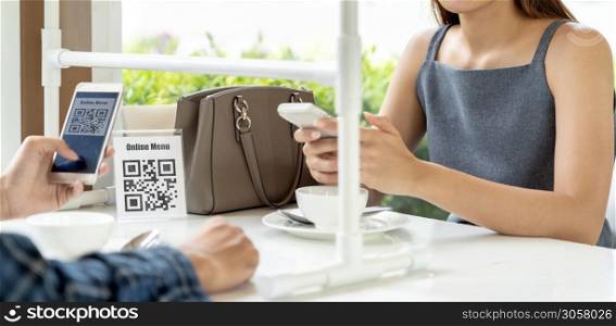 Panorama Asian customers scan QR code online menu. Customers sat on social distancing table for new normal lifestyle in restaurant after coronavirus covid-19 pandemic.