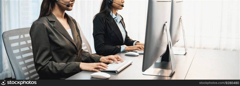 Panorama call center operator team or telesales representative siting at office desk wearing headset and engaged in conversation with client providing customer service support or making sales. Prodigy. Panorama call center operator or telesales agent working on his desk. Prodigy