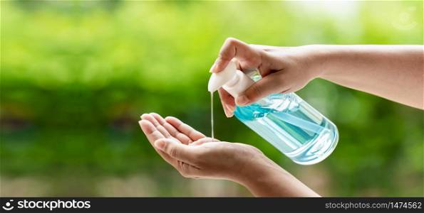 Panorama cleaning hand using alocohol gel waterless in pump bottle, disinfection for safety prevent and protect from virus Covid-19 coronavirus infection world pandemic. Panoramic web banner crop.