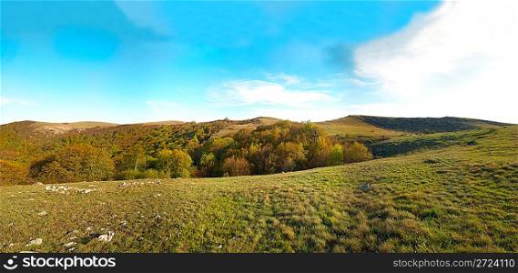 Panorama. Hills with cloudscape and blue sky.