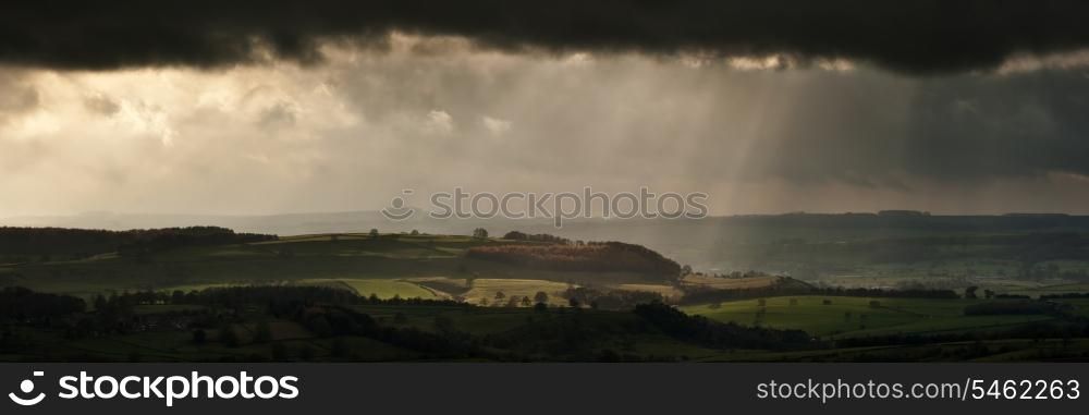 Panorama landscape dramatic sky with sun beams over countryside during Autumn