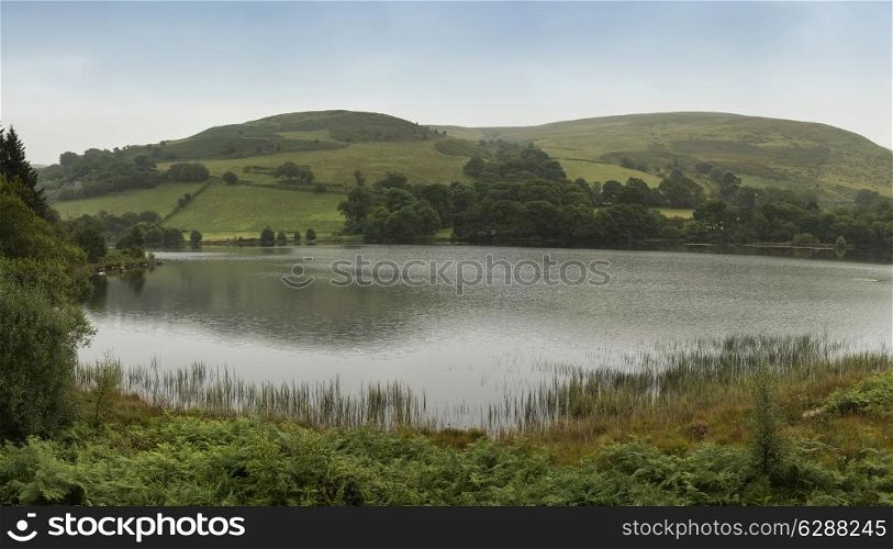 Panorama landscape of lake with rolling hills in background