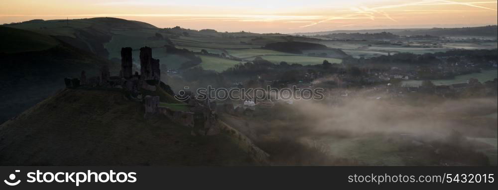 Panorama landscape of medieval castle in misty sunrise morning