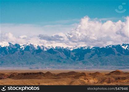 Panorama of a beautiful landscape with trees and fields in the foreground and mountain ranges with snow-capped in the background. Kazakhstan.. Panorama of a beautiful landscape with trees and fields in the foreground and mountain ranges with snow-capped in the background. Kazakhstan