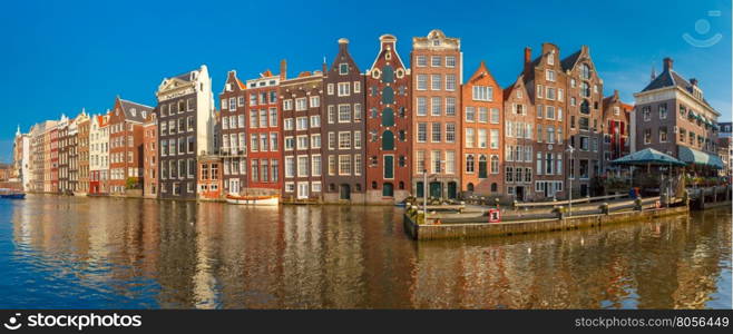 Panorama of beautiful typical Dutch dancing houses at the Amsterdam canal Damrak in sunny day, Holland, Netherlands.