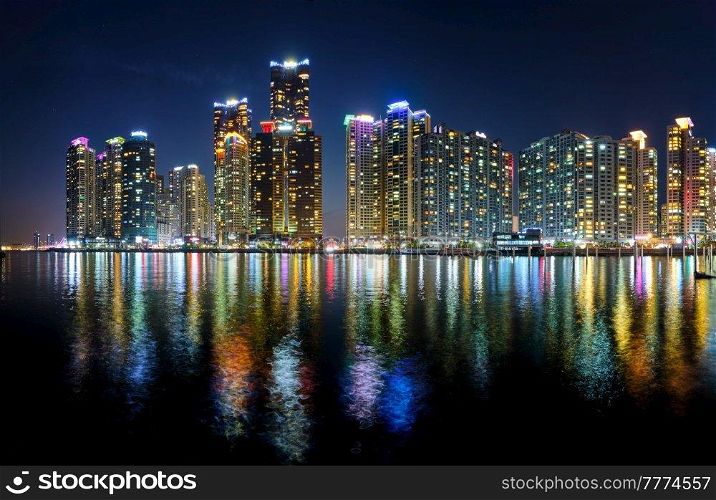 Panorama of Busan Marina city skyscrapers illluminated in night with reflection in water, South Korea. Busan Marina city skyscrapers illluminated in night