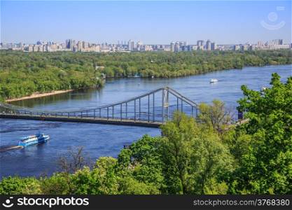 Panorama of city landscape and nature. Kiev, Ukraine. Green trees, architecture, bridges and blue river