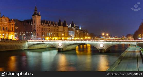 Panorama of Conciergerie and Illuminated bridge Pont au Change at night, Paris, France