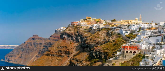 Panorama of Fira, modern capital of the Greek Aegean island, Santorini, in the sunny day, Greece