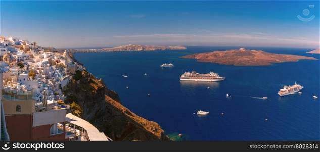 Panorama of Fira, modern capital of the Greek Aegean island, Santorini, with orthodox church, cruise ships, caldera and volcano, Greece