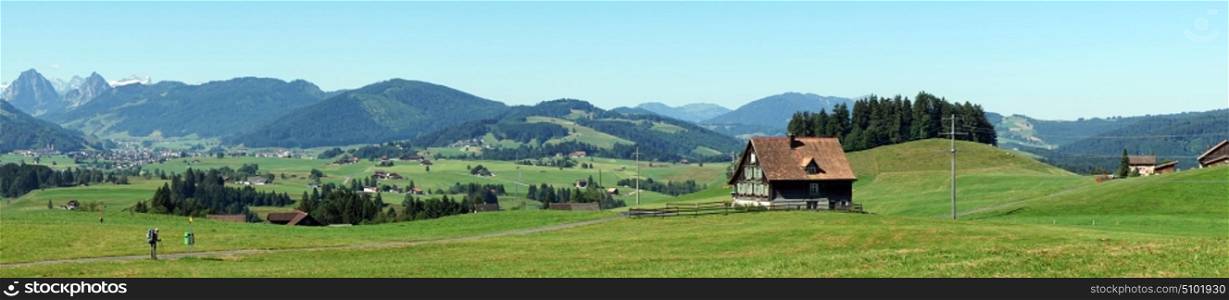 Panorama of green pasture and farm house
