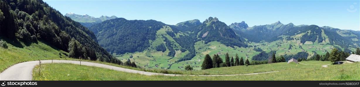 Panorama of long road on the green slope of mount in Switzerland