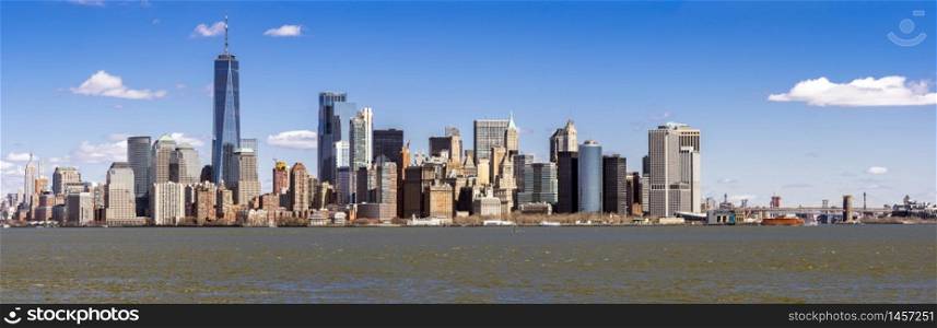Panorama of Lower Manhattan of New York City with USA Flag from liberty island. This also known as Downtown Manhattan or Downtown New York the largest business district in state of New York and USA.