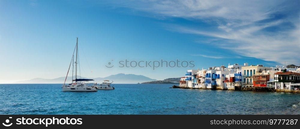 Panorama of sunset in Mykonos island, Greece with yachts in the harbor and colorful waterfront houses of Little Venice romantic spot on sunset and cruise ship. Mykonos townd, Greece. Sunset in Mykonos, Greece, with cruise ship and yachts in the harbor