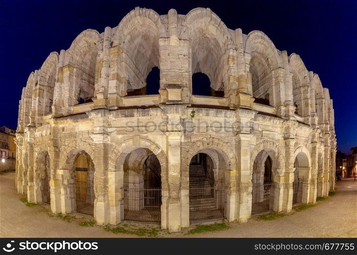 Panorama of the old antique roman amphitheater arena in night lighting. Arles. France. Provence. France. Arles. Old antique roman amphitheater arena.