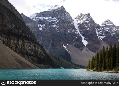 Panorama of turquoise lake in front of snowy mountains in Canada