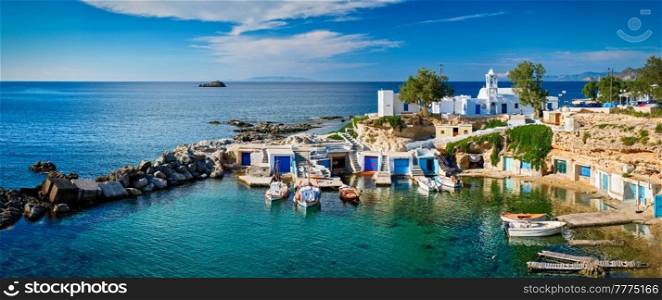 Panorama of typical Greece scenic island view - small harbor with fishing boats in crystal clear turquoise water, traditional white houses church. Mandrakia village, Milos island, Greece.. Mandrakia village in Milos island, Greece