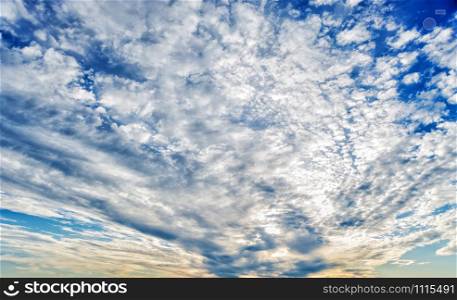 Panorama of vast blue summer sky with fluffy white clouds
