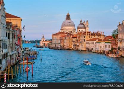 Panorama of Venice Grand Canal with boats and Santa Maria della Salute church on sunset from Ponte dell’Accademia bridge. Venice, Italy. Panorama of Venice Grand Canal and Santa Maria della Salute church on sunset