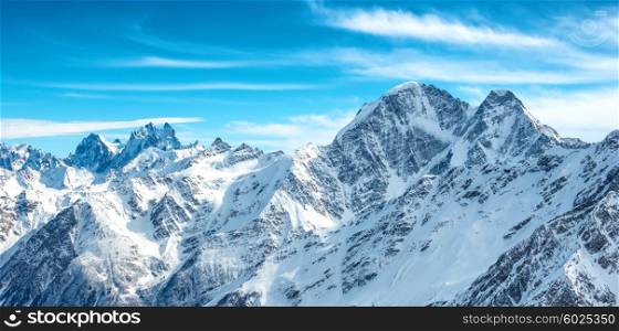Panorama of white mountains in snow. Landscape with blue peaks