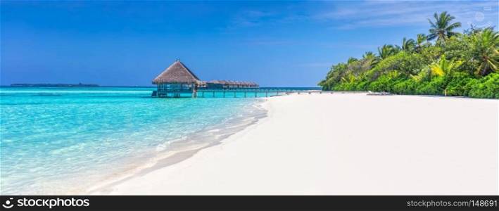 Panorama of wide sandy beach on a tropical island in Maldives. Coconut palms and water lodge on Indian Ocean.. Panorama of wide sandy beach on a tropical island in Maldives, Indian Ocean.