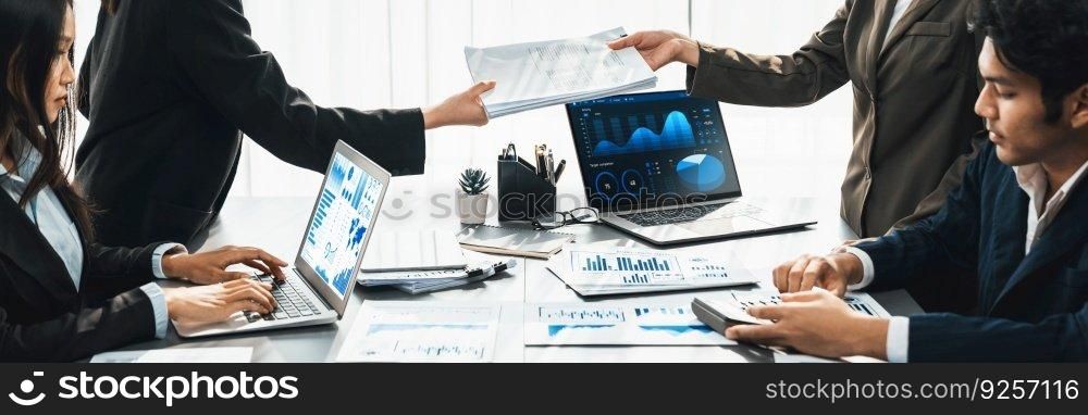 Panorama shot analyst team utilizing BI Fintech to analyze financial report with laptop. Businesspeople analyzing BI data dashboard displayed on laptop screen for business insight. Prodigy. Analyst team utilizing BI Fintech to analyze financial report. Prodigy