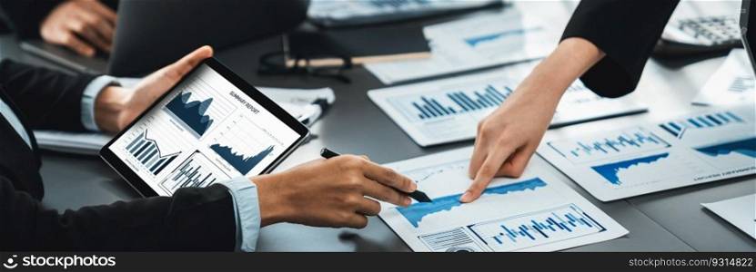 Panorama shot analyst team utilizing BI Fintech to analyze financial report with tablet. Businesspeople analyzing BI data dashboard displayed on tablet screen for business insight. Prodigy. Analyst team utilizing BI data on tablet for business marketing. Prodigy