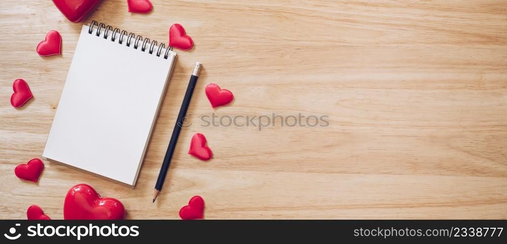 panorama shot of top view notepad and red heart on wood background for valentine day with copy space.