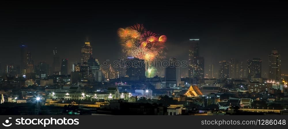 panorama view of beautiful firework explosion over bangkok city skyscraper