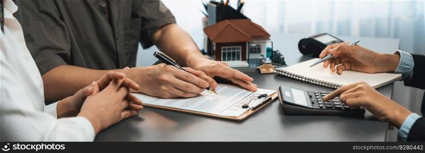 Panorama view of married couple signing house loan contract with real estate agent. Client customer purchasing new home, sealing the deal with signatures after reviewing terms and agreements. Prodigy. Panorama view of married couple signing house loan contract with broker. Prodigy
