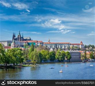 Panorama view of Vltava river and Gradchany (Prague Castle) and St. Vitus Cathedral and Charles bridge an people in paddle boats in the Prague, Czech Republic