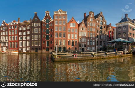 Panorama with beautiful typical Dutch dancing houses at the Amsterdam canal Damrak in sunny day, Holland, Netherlands.