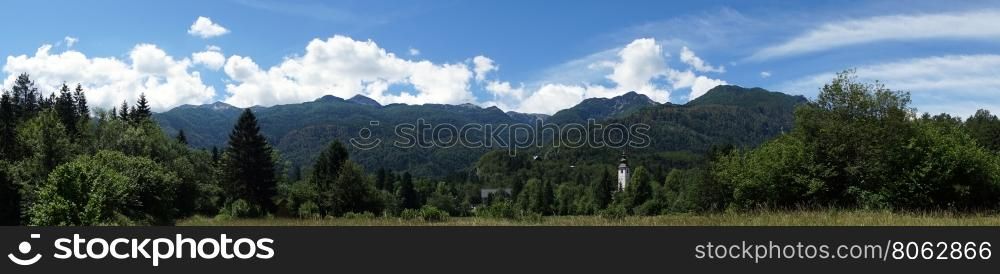 Panorama with church tower and forest near Bohinj lake in Slovenia