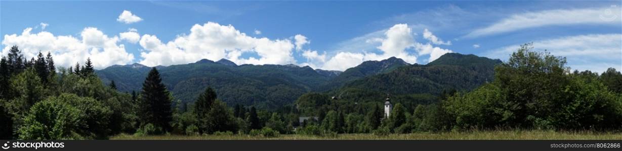 Panorama with church tower and forest near Bohinj lake in Slovenia