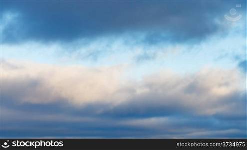 panorama with gray winter cloud layers in blue afternoon sky