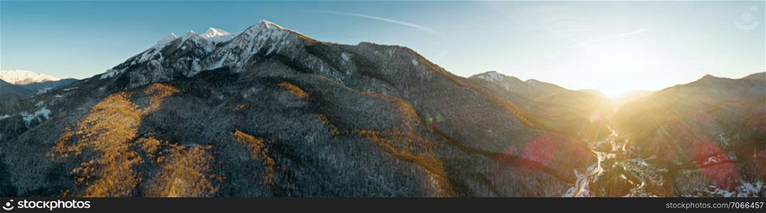 Panoramic aerial drone view on mountains around Krasnaya Polyana, Sochi, Russia. Mountain slopes in last golden light of sunset