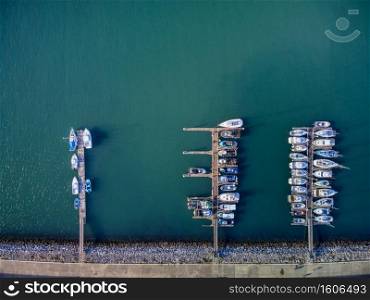 Panoramic Aerial view on boats moored in the pier, drone shot directly above. Luanco in Asturias, Spain.