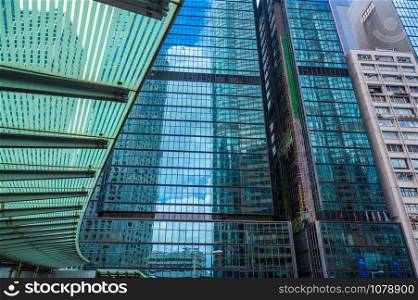 Panoramic and perspective wide angle view to steel blue background of glass high rise building skyscrapers in modern futuristic downtown