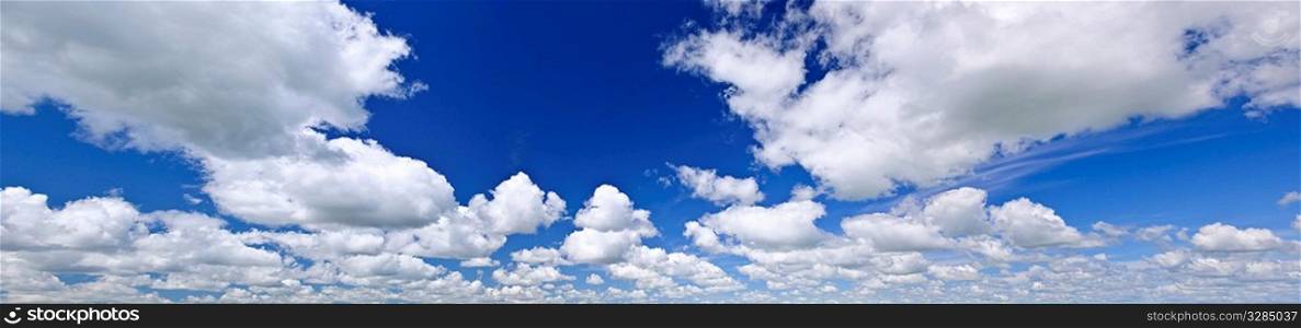 Panoramic background of blue sky with white cumulus clouds