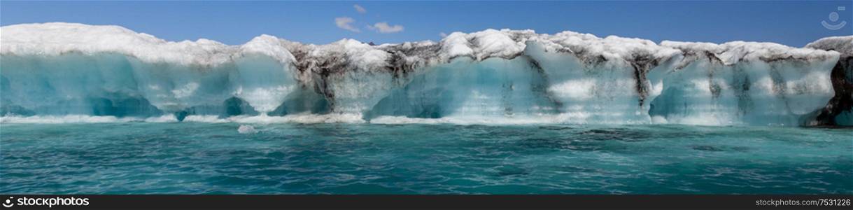 Panoramic climate change global warming concept, huge melting Icebergbreaking off the Breidamerkurjokull Glacier into Jokulsarlon Lagoon, Iceland panorama web banner
