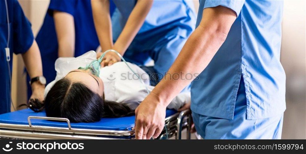 Panoramic Close up Medical team do CPR to seriously injured patient with oxygen mask while push gurney stretcher bed to Operating Room. Emergency health care and medical hospital concept.