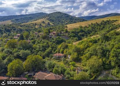 Panoramic Drone Aerial View view of mountain peaks. Hilltops covered with forest. Green nature background aerial view mountain landscape.